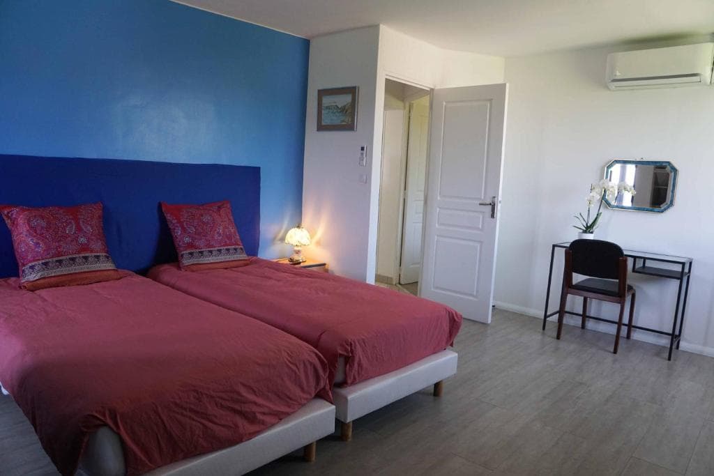 Chambre avec lit double, mur bleu et climatisation individuelle